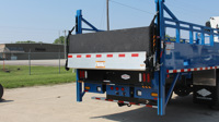 Bi-Fold, High-Cycle Railgate in the stored position on a stake truck.